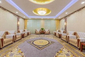 A hotel room with a large carpet, sofas, and a chandelier. - Grand Hotel Yuanshan (Beijing)