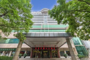 Un hotel de varios pisos con una entrada destacada, amplios ventanales y un diseño arquitectónico moderno.