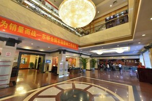 A spacious lobby with a high ceiling, a central chandelier, and a large digital clock. - Grand Hotel Yuanshan (Beijing)