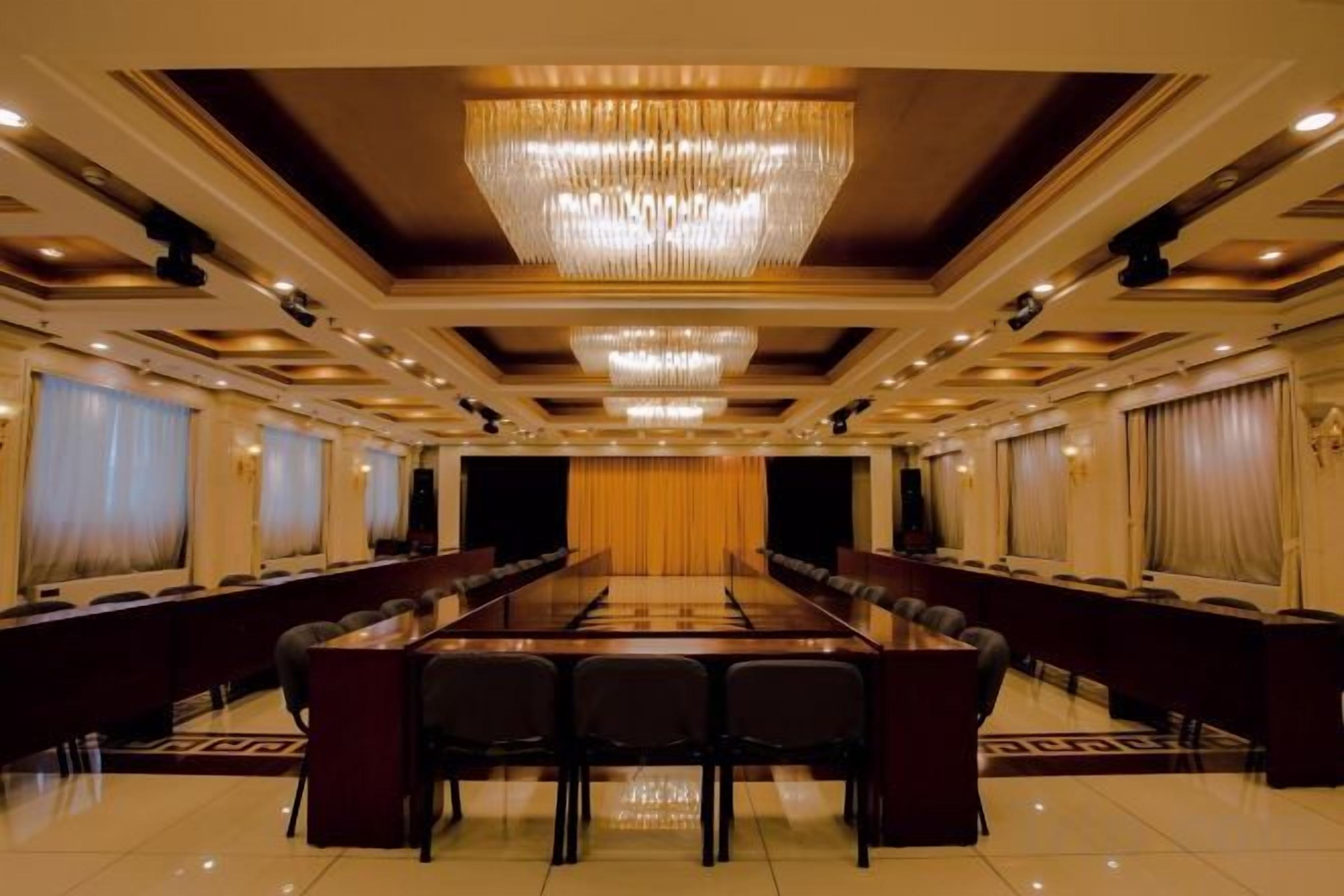 A conference room with a long table, chairs, and a chandelier.