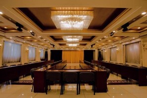 A conference room with a long table, chairs, and a chandelier. - Grand Hotel Yuanshan (Beijing)