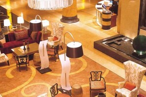 A lobby with a central fountain, seating areas, and a reception desk. - International Hotel (Langfang)