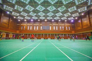 Una cancha de bádminton interior con techo alto y paredes de madera.
