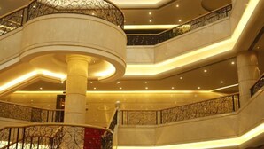 Een meerlaags interieur met een centrale kolom, versierde balustrades en een warme sfeerverlichting.