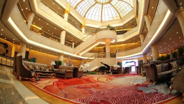 Een ruime atrium met een hoge plafond, meerdere niveaus, en een vleugelpiano in het midden.