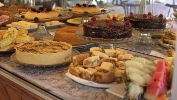Um buffet com diversos doces e frutas.