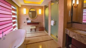 A modern bathroom with a freestanding bathtub, a vanity with a mirror, and a glass shower enclosure. - Sanbu Holiday Hotel (Jiangmen)