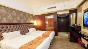 A hotel room with two beds, a large mirror, a television, and a carpeted floor. - Sanbu Holiday Hotel (Jiangmen)