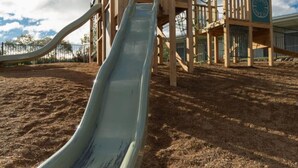 A playground with a slide and climbing structures. - Shoreline Hotel (Howrah)