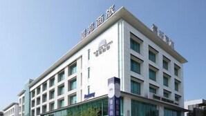 A multi-story hotel building with a modern architectural design, featuring a prominent entrance with glass doors and a signboard.