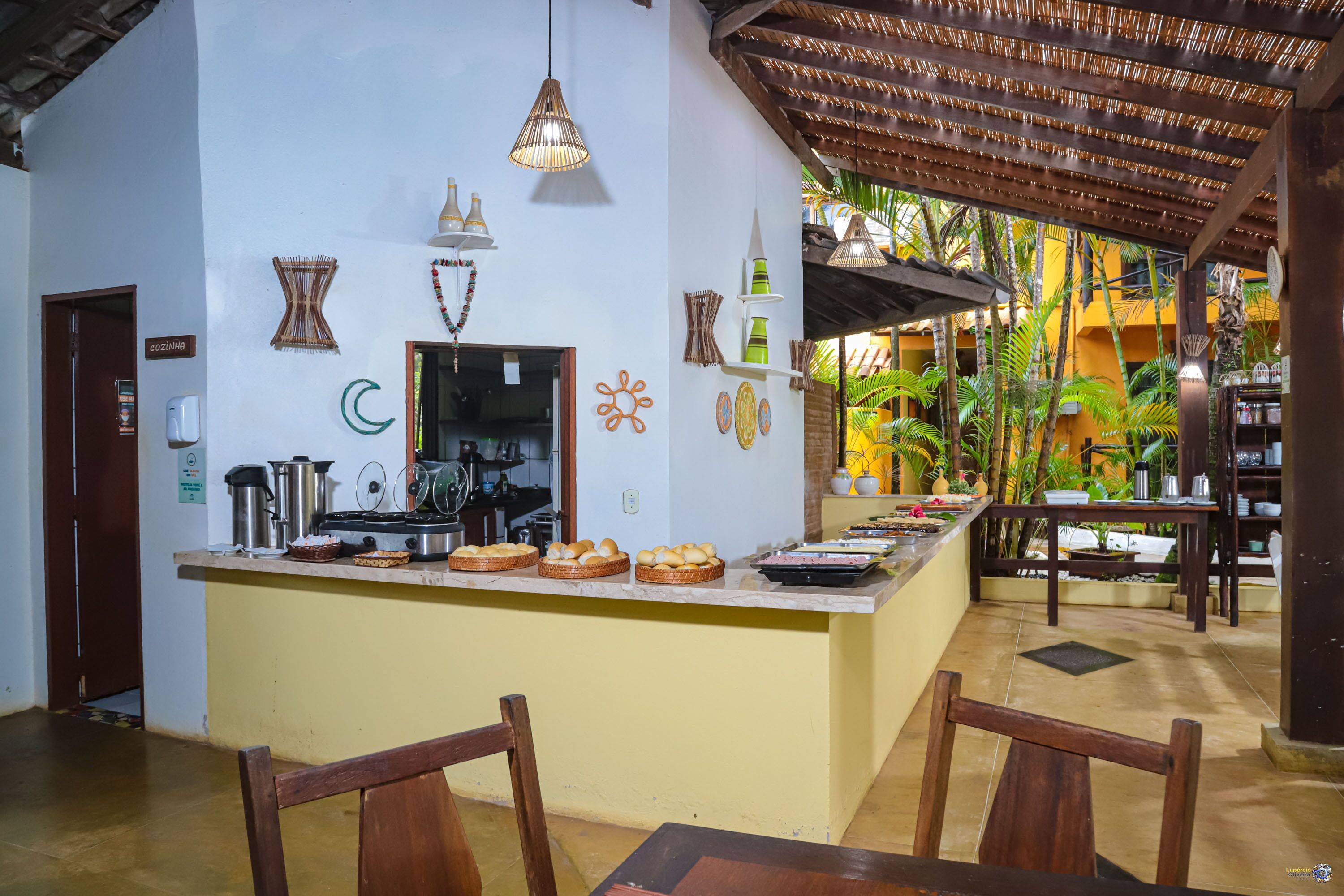 A kitchen area with a central island, wooden chairs, and a variety of kitchen utensils and appliances.