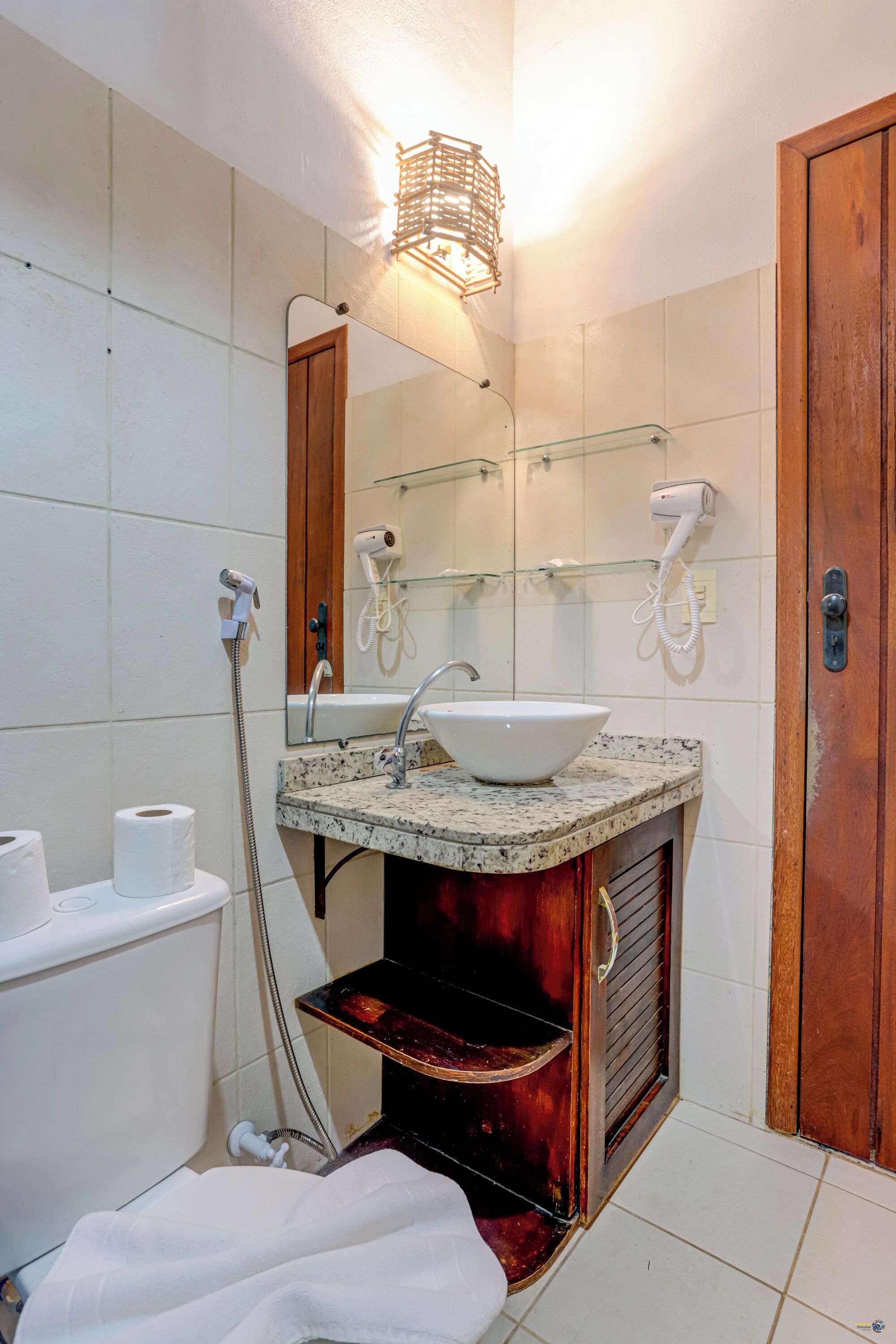 A bathroom with a sink, mirror, towel rack, and a shower.