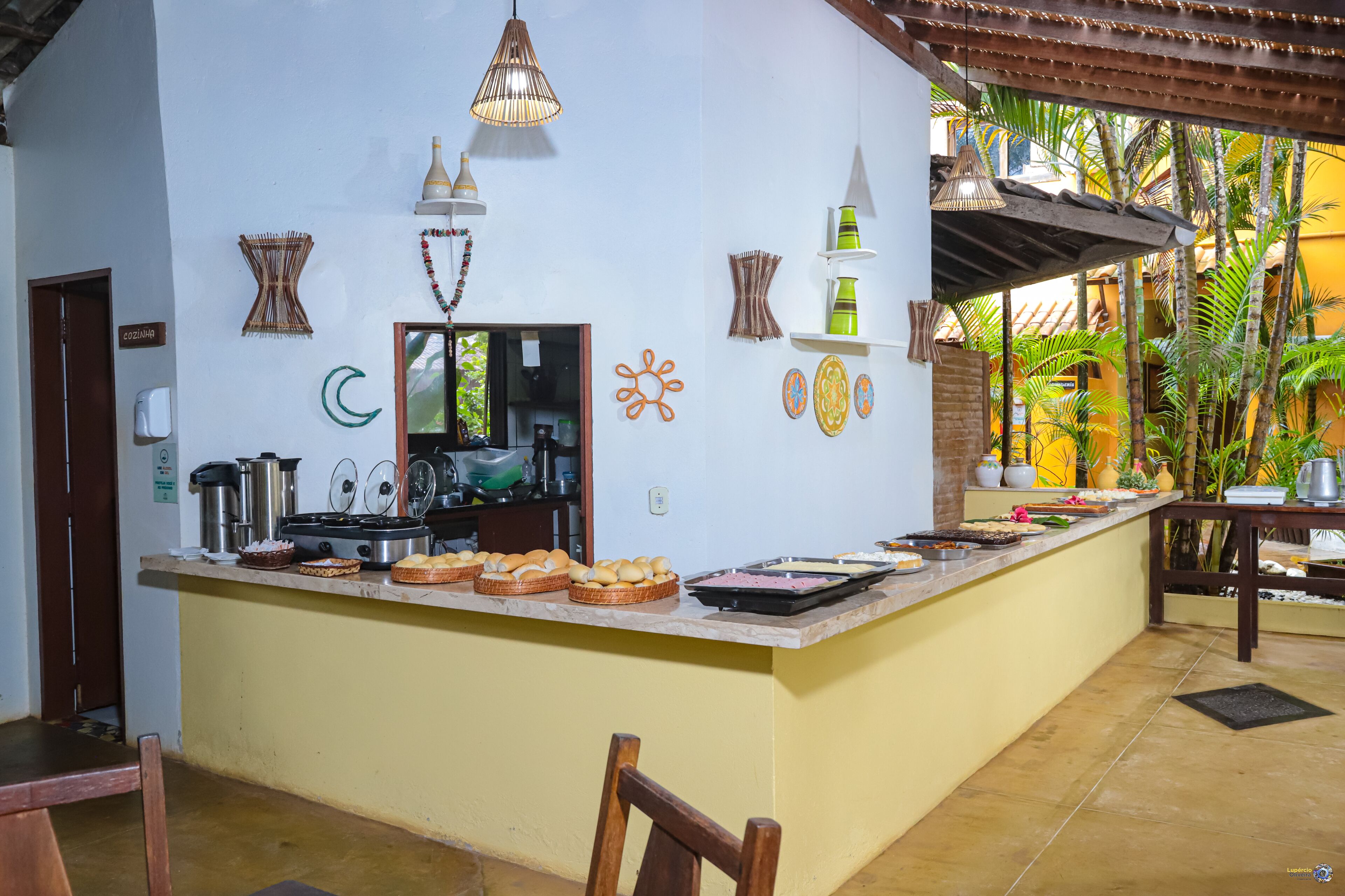 A kitchen with a central island, various kitchen appliances, and decorative items on the walls.