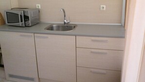 A small kitchenette with a microwave, sink, and cabinets. - Sunset Kosharitsa (KOSHARITSA)