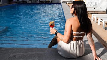 Una piscina al aire libre, camas de piscina gratis, sombrillas