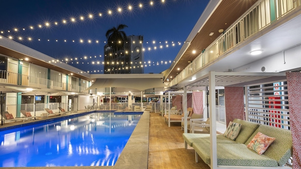 A swimming pool with lounge chairs and a covered seating area. - Nightcap at the Cavenagh (Darwin)