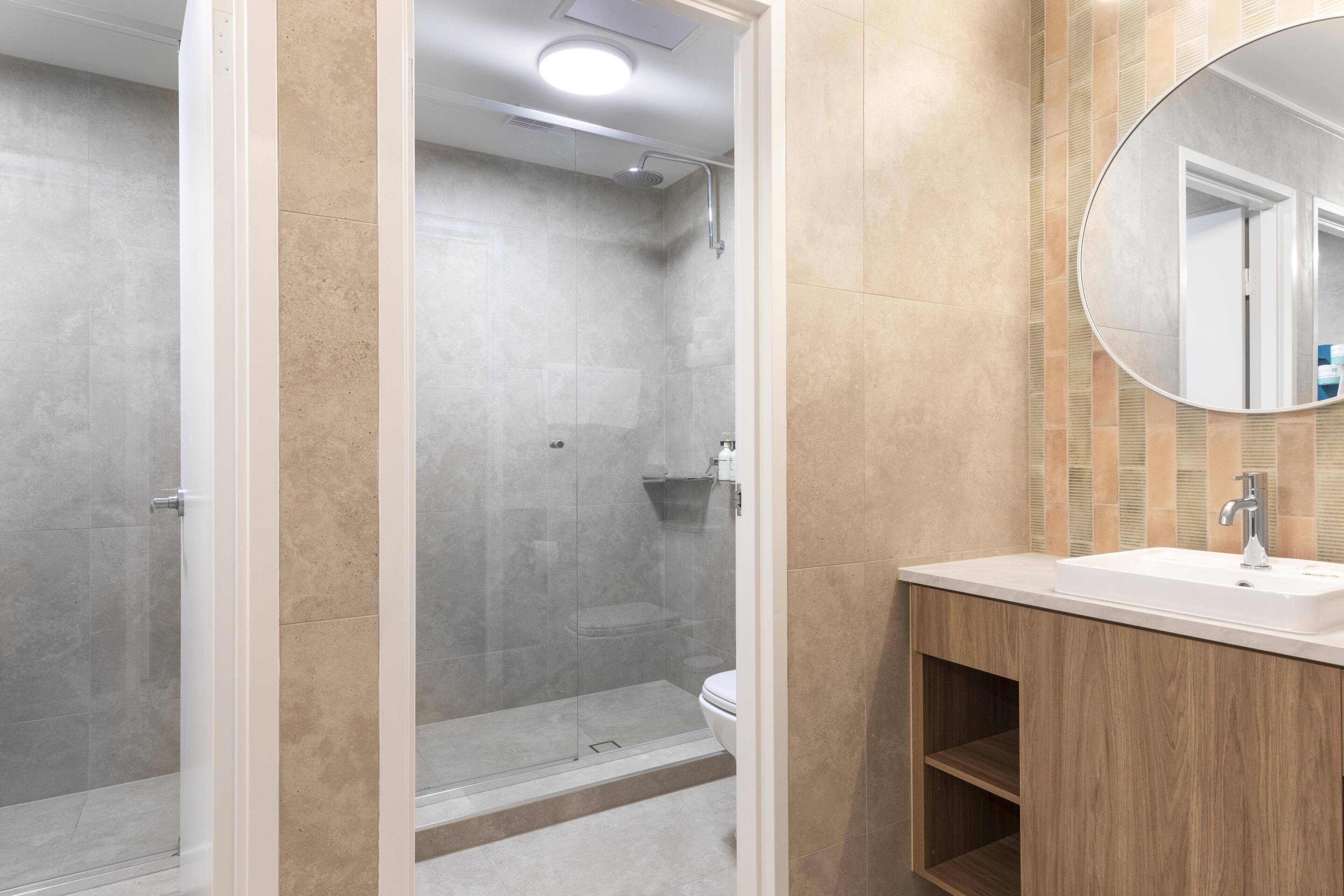 Une salle de bain moderne équipée d’une douche, de toilettes et d’un lavabo.