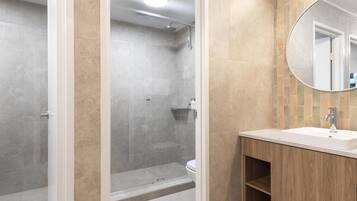 Une salle de bain moderne équipée d’une douche, de toilettes et d’un lavabo.