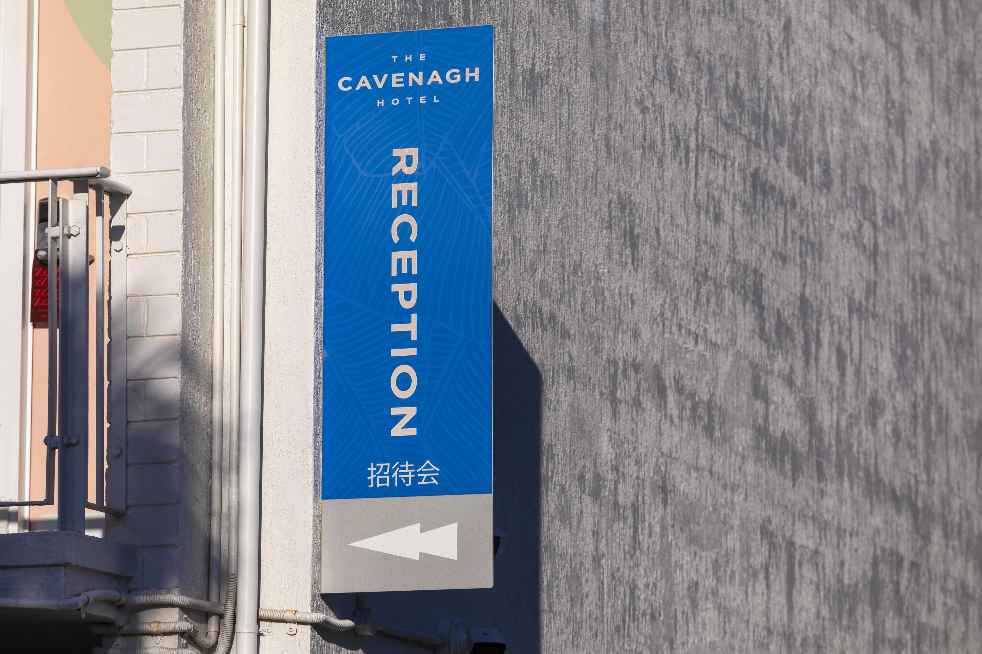 Placa de recepção do Hotel Cavenagh com uma seta apontando para baixo.