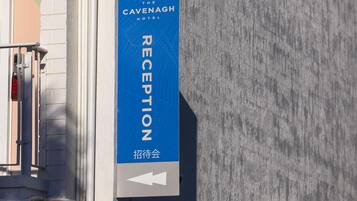 Placa de recepção do Hotel Cavenagh com uma seta apontando para baixo.