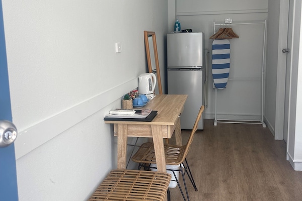 Tabla de planchar con plancha y ropa de cama