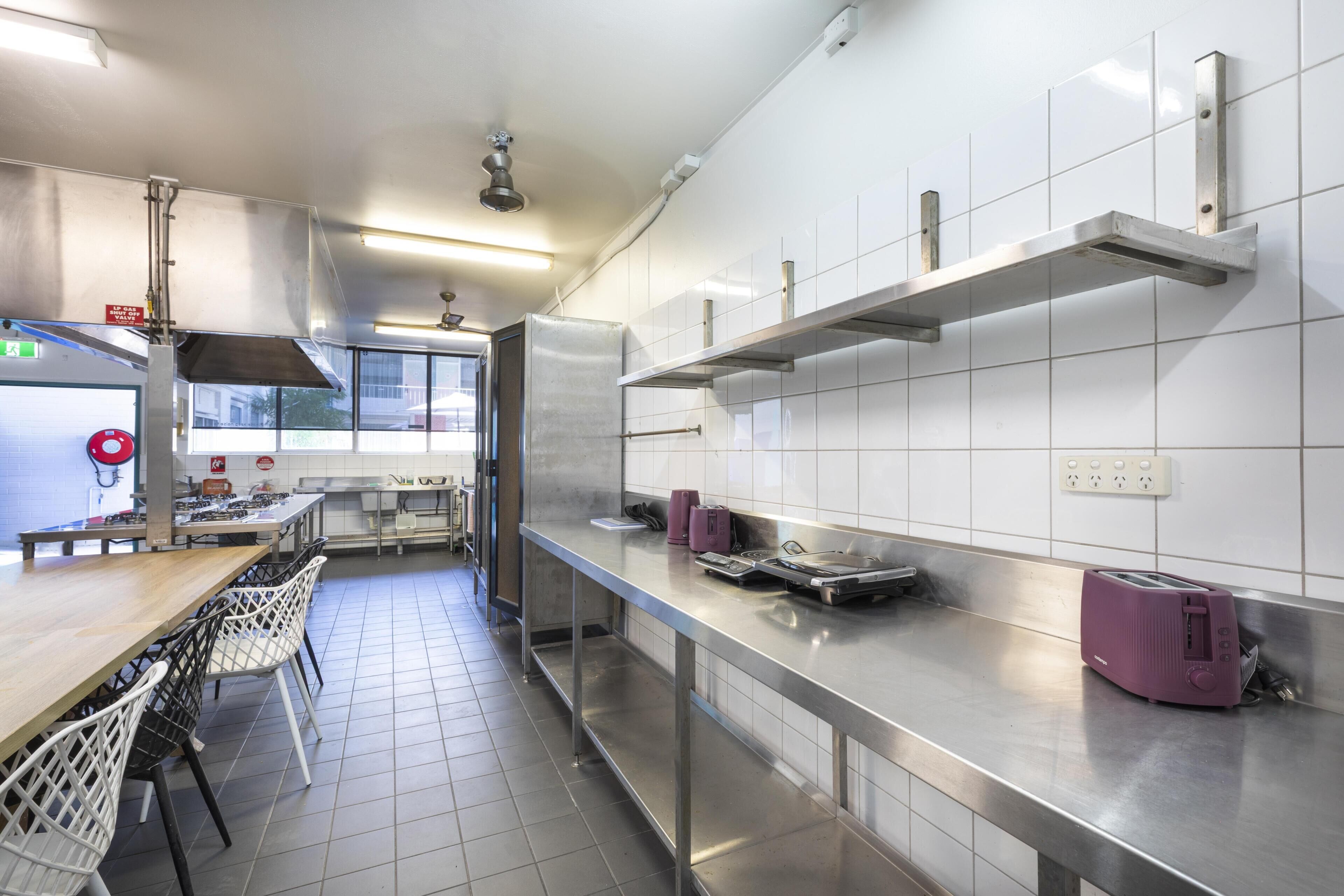 A modern kitchen with stainless steel appliances, a long counter, and a window providing natural light.