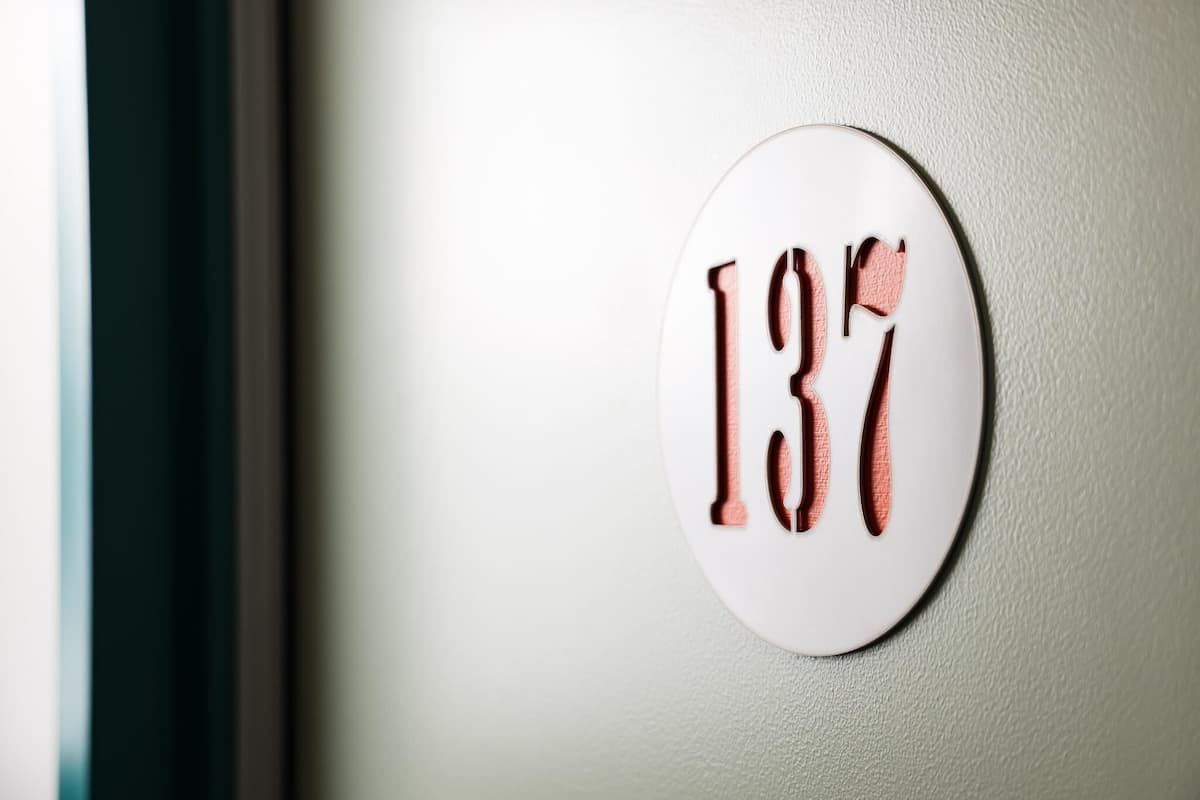 A white circular sign with the number '137' on a wall.