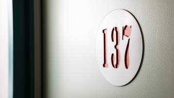 Una señal blanca circular con el número 137 en una pared.