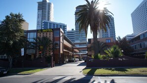 A hotel with a modern design, a parking lot, and a palm tree. - City Waters Perth (Perth)