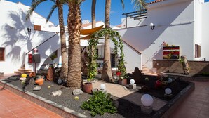 A courtyard with palm trees, potted plants, and a tiled floor. - Apartamentos Villa Florida (Antigua)