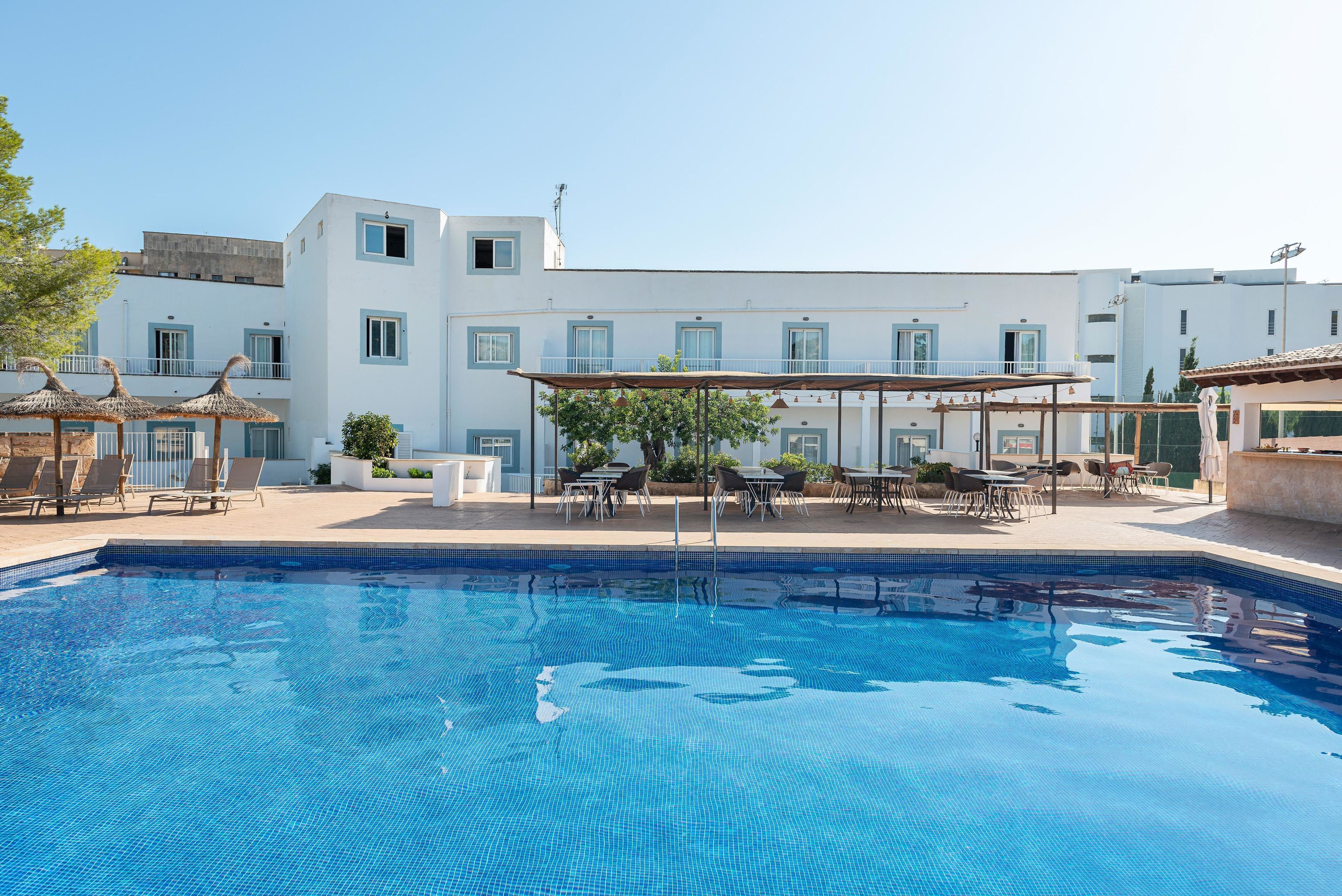 Una piscina al aire libre de temporada, sombrillas