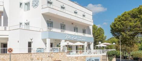 Un edificio blanco con balcones y un letrero que dice "Villa Real Club Apartments".