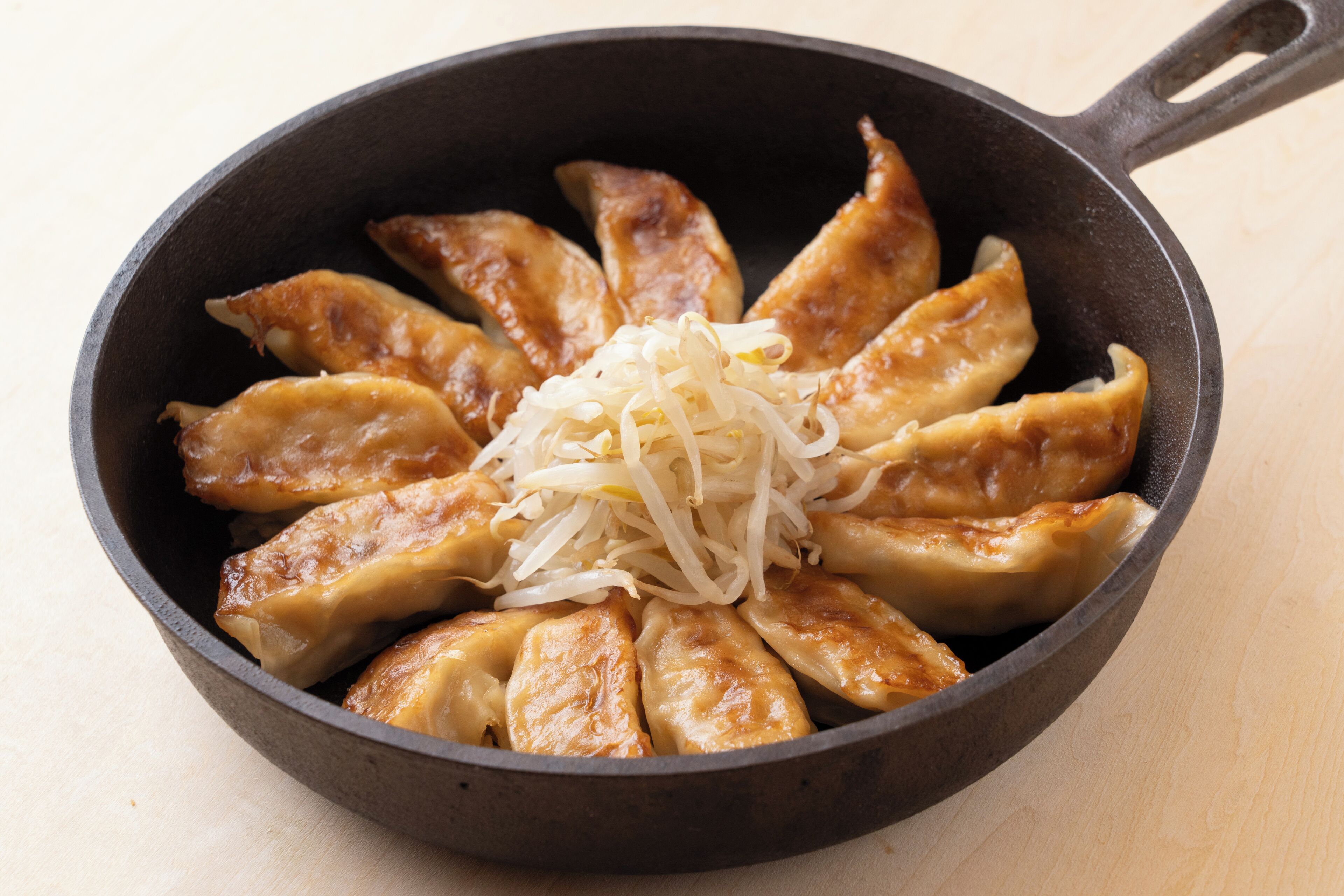 A skillet with cooked dumplings and shredded cabbage.