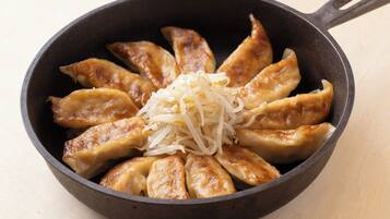 A skillet with cooked dumplings and shredded cabbage.