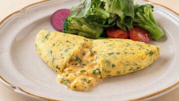 A plate with an omelette, broccoli, and cherry tomatoes.