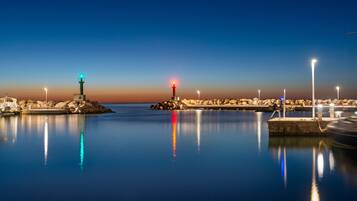 Una orilla tranquila con un faro y un muelle.