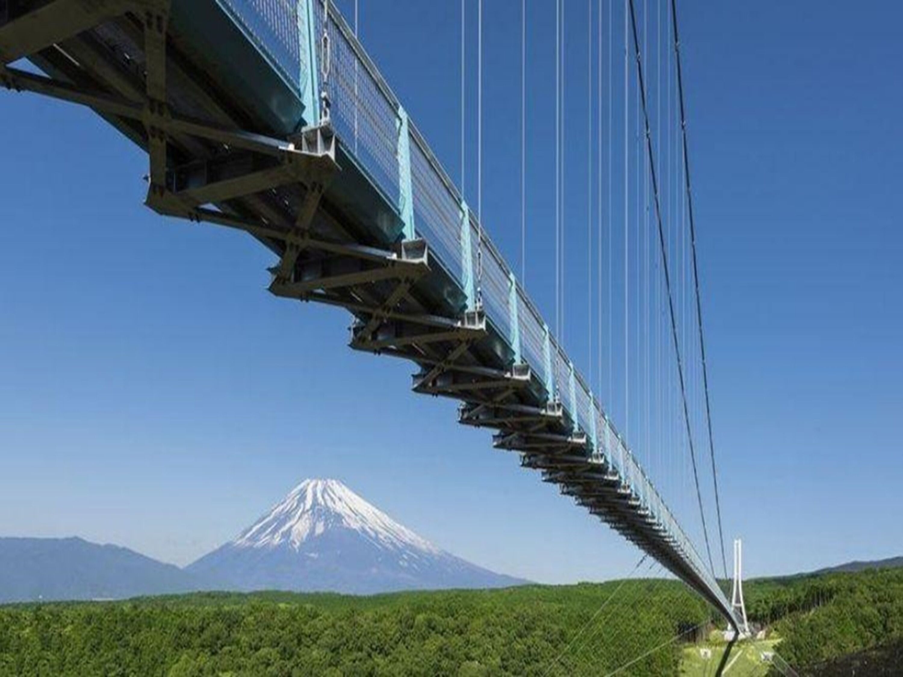 A suspension bridge with a mountain in the background.