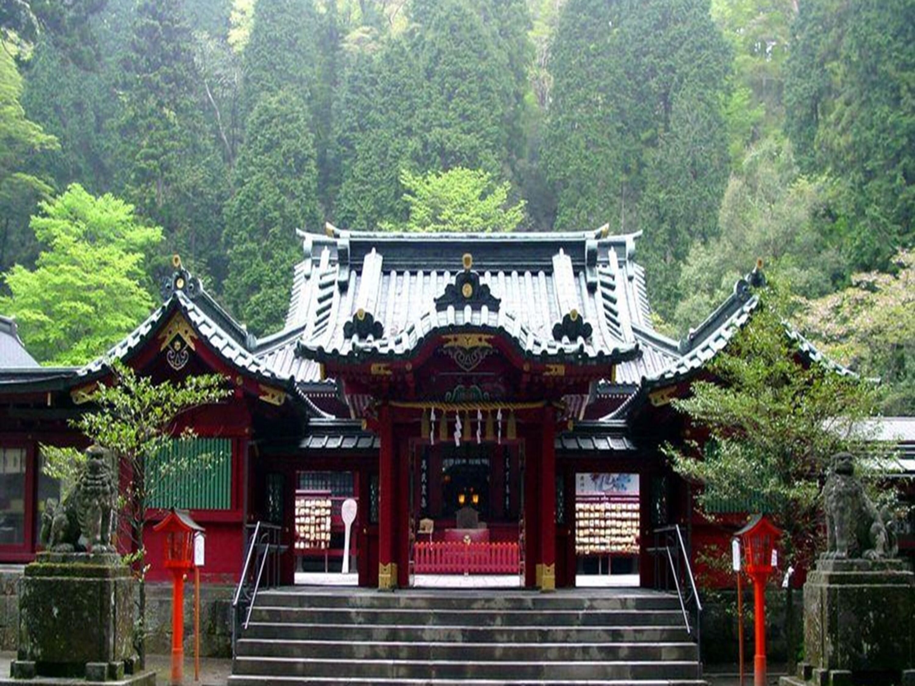 A traditional Japanese temple with a curved roof and a red entrance gate.