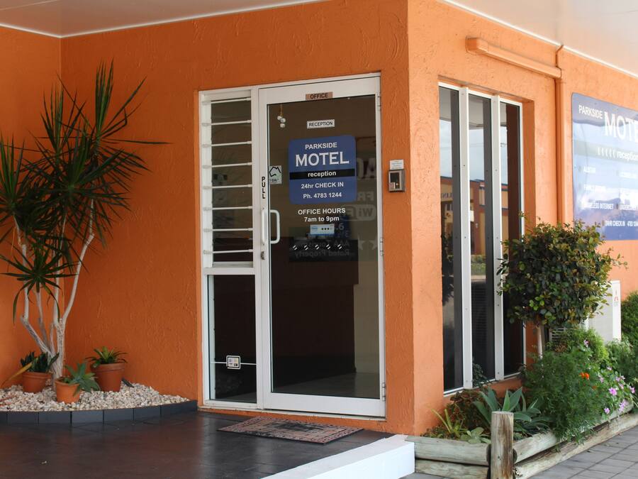 A motel with a reception desk, a phone number, and office hours.