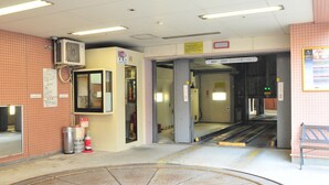 A public indoor space with a tiled floor, a fire extinguisher, and a ventilation unit. - Hotel Sunroute Sopra Kobe (Kobe)