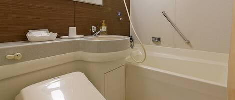 A modern bathroom with a toilet, sink, and bathtub.