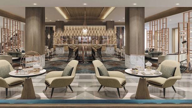 Un hall espacioso con una zona de estar central, un bar y una escalera.