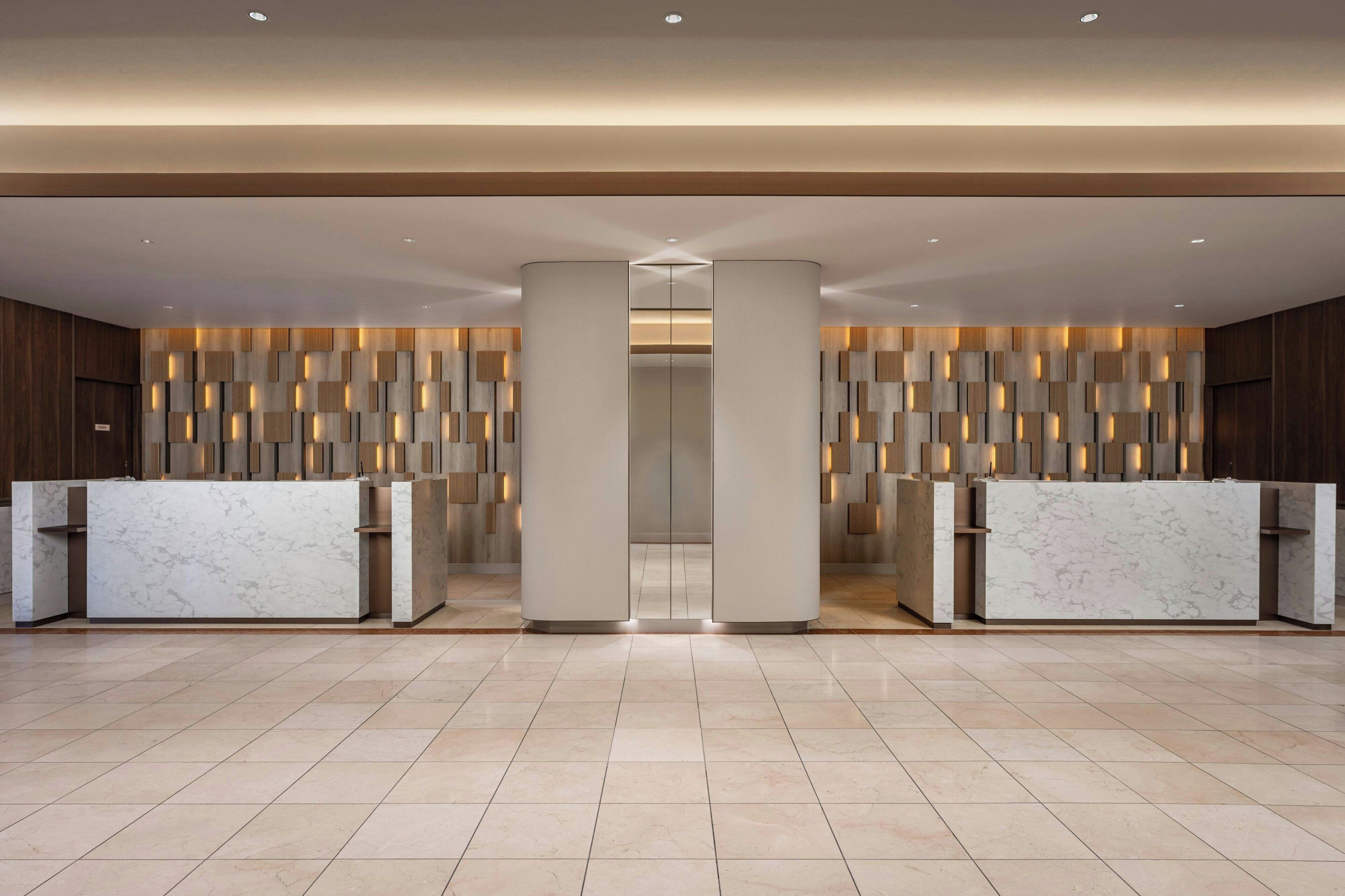 A modern reception area with marble counters and a patterned wall design.
