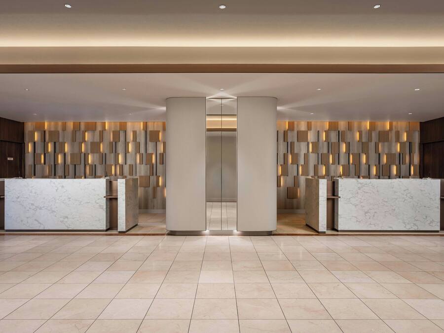 A modern reception area with marble counters and a patterned wall design.