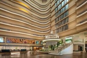 A spacious lobby with a central staircase, a large mural, and a modern ceiling design. - Hamamatsu Marriott Hotel (Hamamatsu)