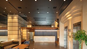 A modern lobby with a reception desk, seating area, and elevators. - EN HOTEL Hamamatsu (Hamamatsu)
