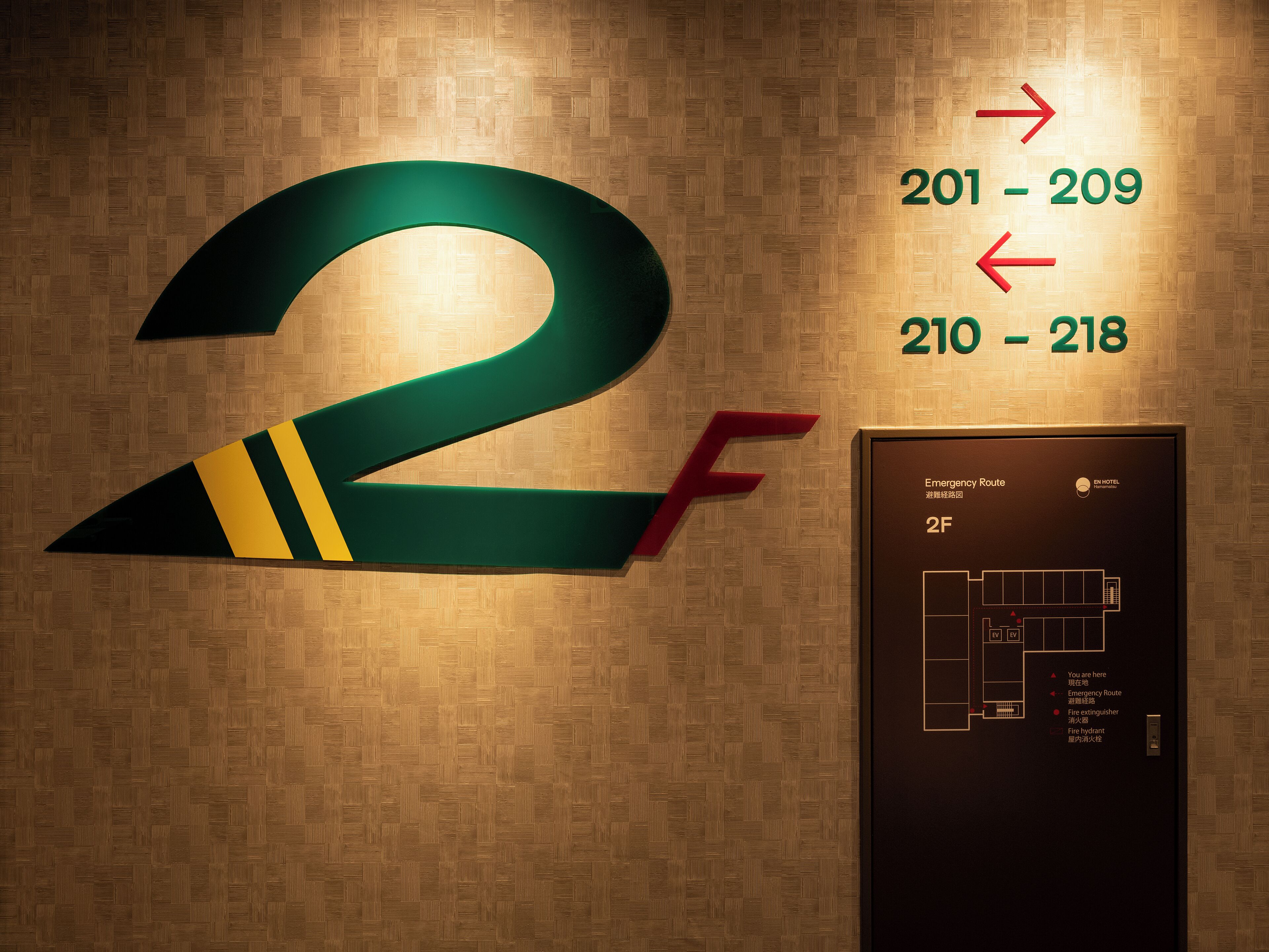 A hotel room number 2F with directional arrows indicating room numbers 201-209 and 210-218.