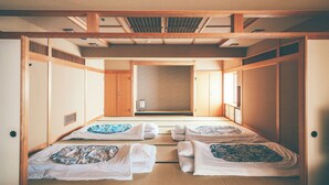 A traditional Japanese-style room with tatami flooring, shoji screens, and a sliding door.