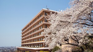 A multi-story building with a modern architectural design, featuring a series of balconies and large windows.