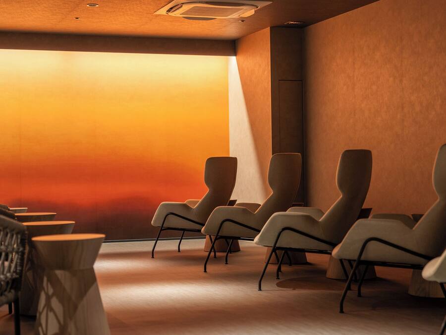 A modern waiting area with several chairs and a wicker chair.